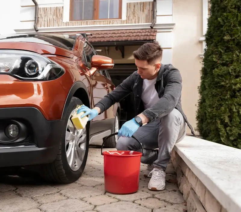 Lavage auto à domicile Isigny-le-Buat : professionnel intervenant sur un véhicule